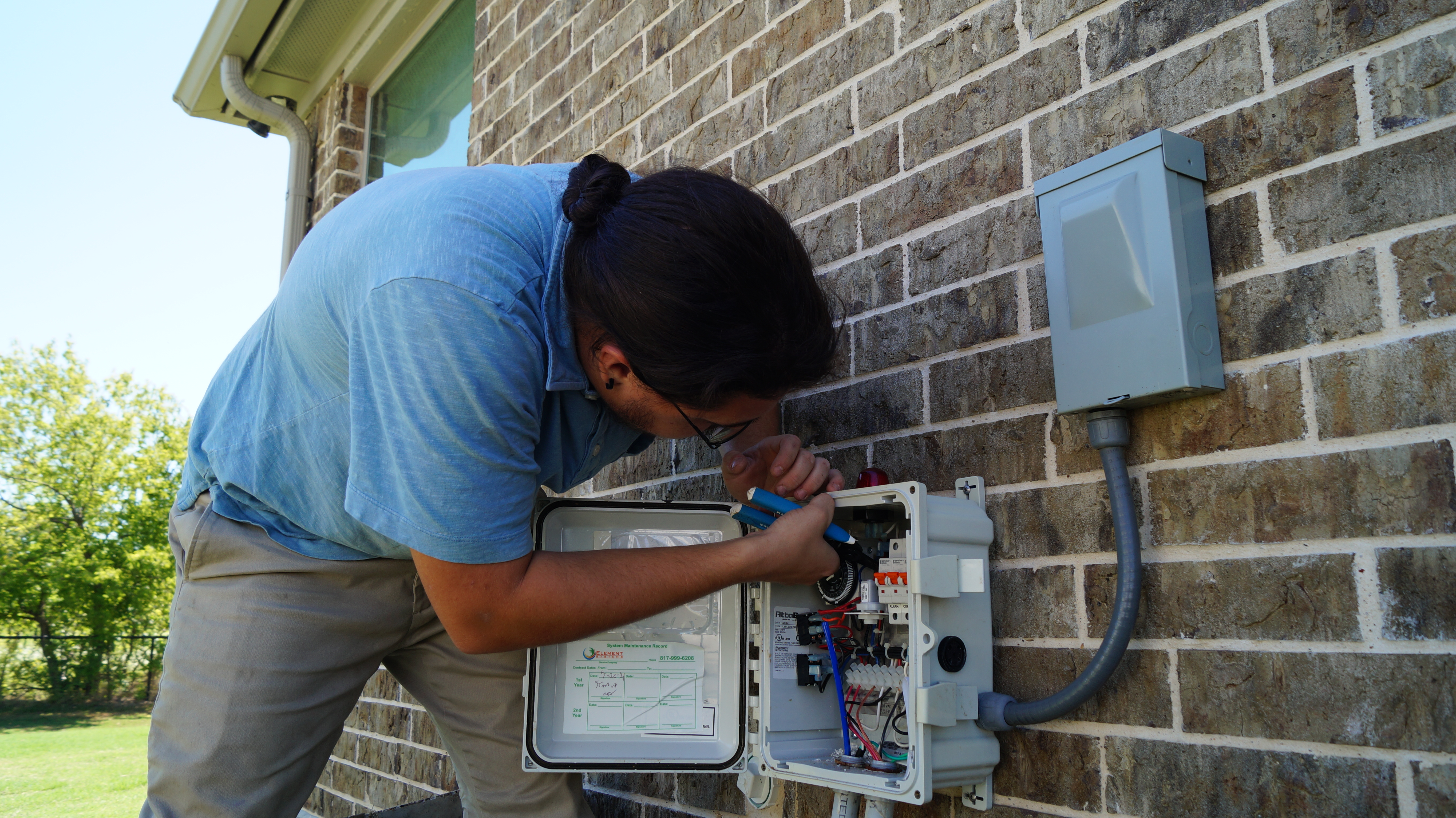 A man works on a septic electrical panel.